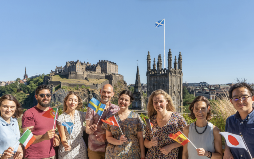 IH Edinburgh team waving flags in front of castle